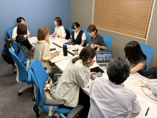 研修を受ける様子。スタッフが着席し、グループに分かれ話をしている。